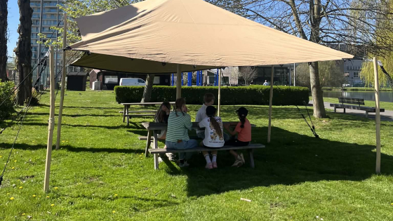 Jongeren zitten onder overkapping aan stadionvijvers