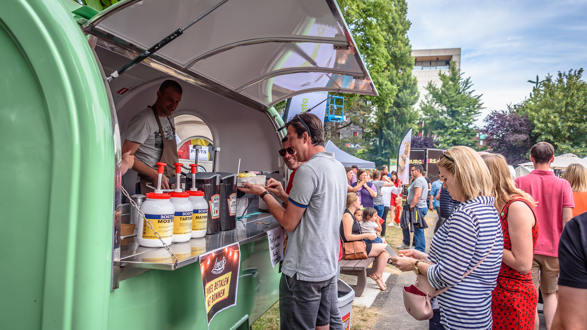 Mensen aan foodtruck in Regenboogpark